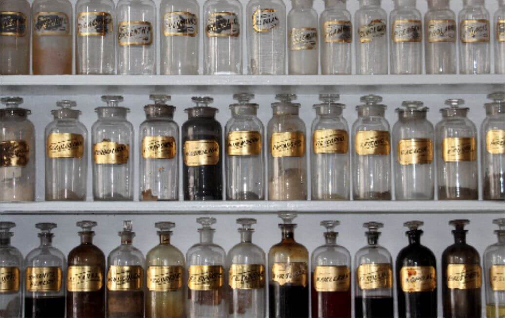 Sun Med Community Wellness Qi Mystical in the Mundane - Glass Bottle with Gold Labels in a Cabinet
